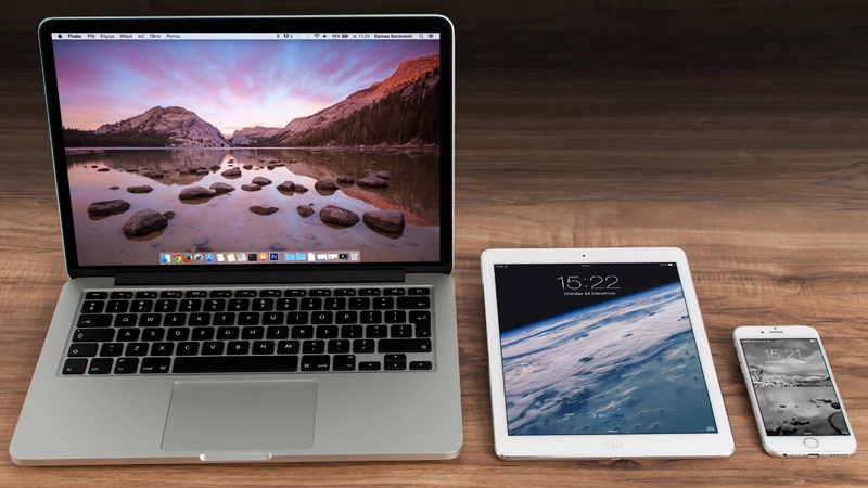 Laptop, tablet, and smartphone placed on a wooden desk